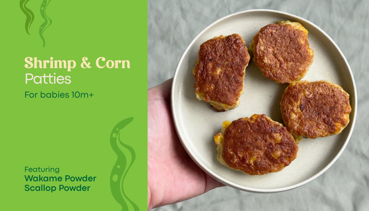 Shrimp and Corn Patty on a white plate with text "For babies 10m+" and "Featuring wakame powder and scallop powder"