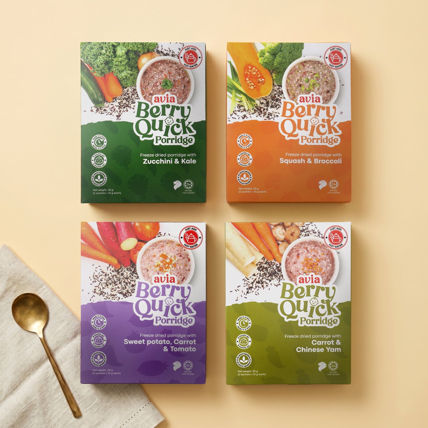 Four boxes of avia Berry Quick Porridge arranged in a 2x2 grid on a warm beige background, with a gold spoon and folded cream cloth in the lower left corner. The boxes feature different flavor color blocks: dark green (Zucchini & Kale), orange (Squash & Broccoli), purple (Sweet potato, Carrot & Tomato), and light green (Carrot & Chinese Yam).
